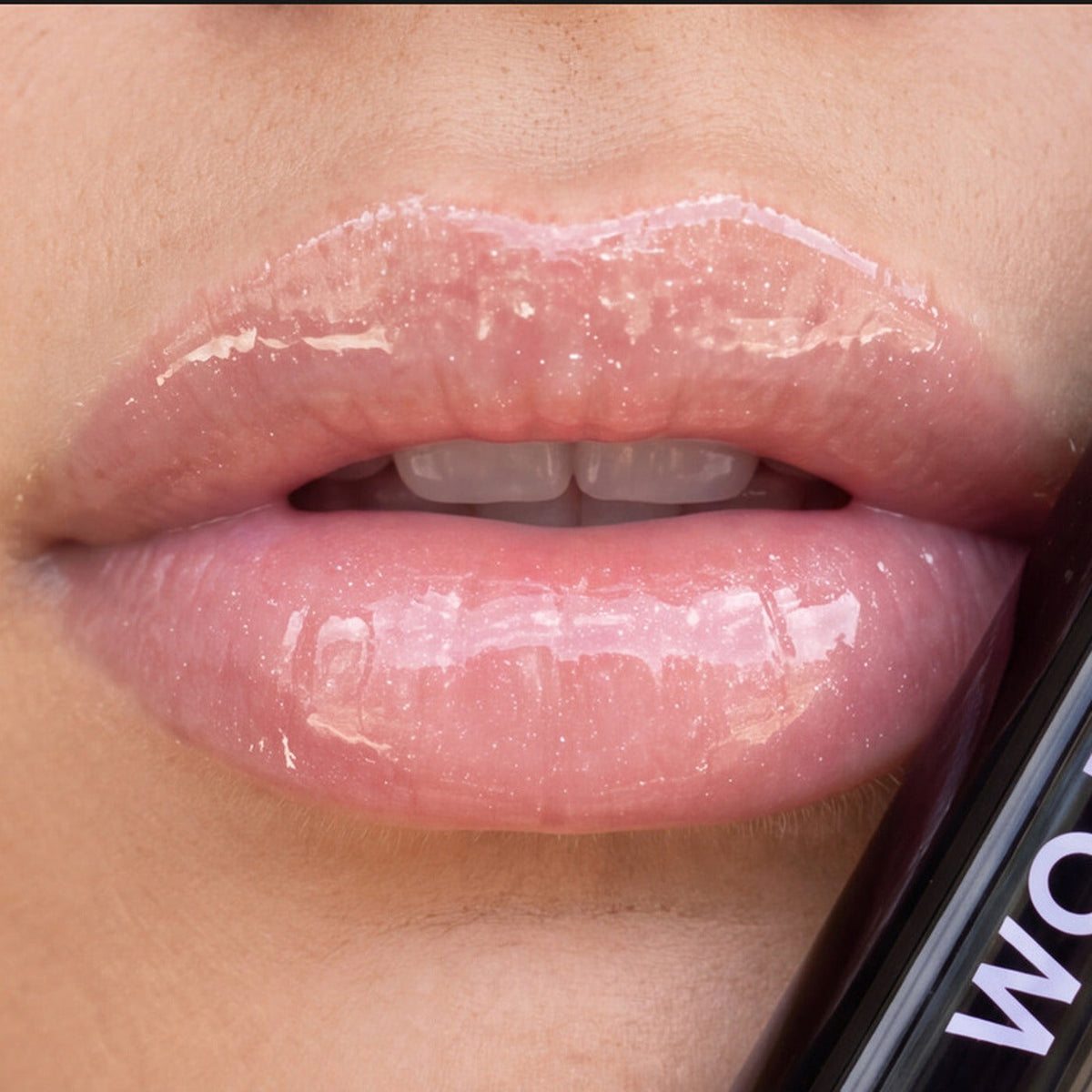 Lips wearing the balm, tube in frame
